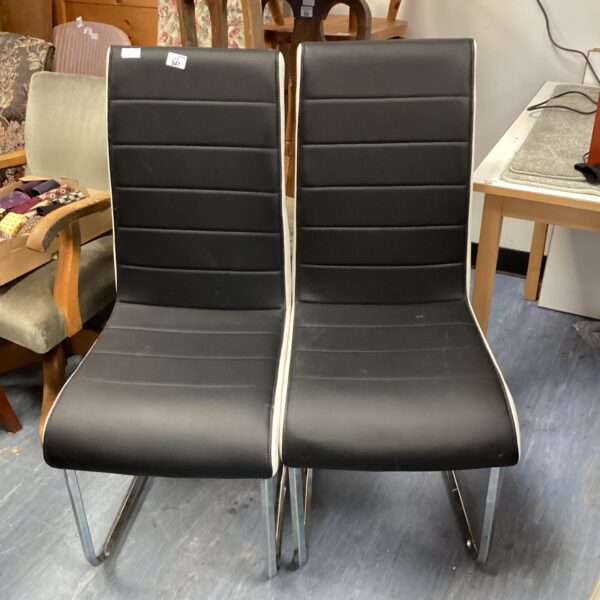 Pair of vintage black and white dining chairs with chrome legs.