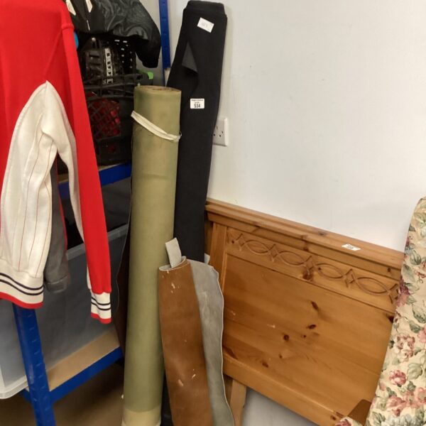 Three rolls of faux leather fabric in varying shades.
