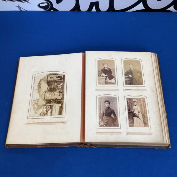 Open Victorian photo album with antique photographs inside.