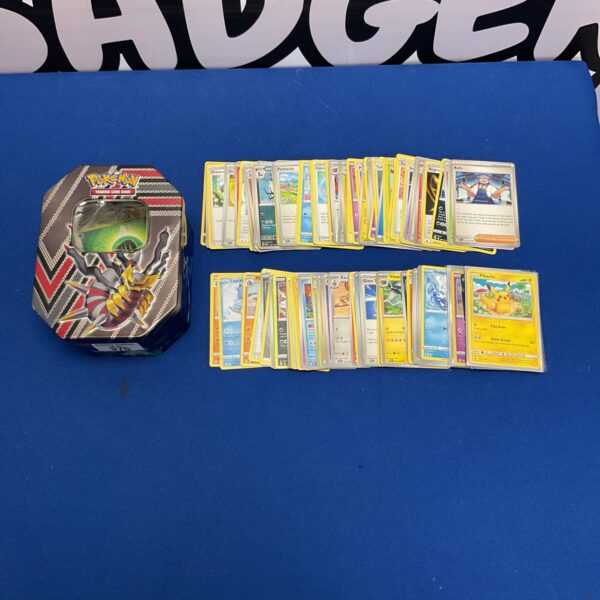 Pokemon card tin with Pikachu and assorted trading cards.