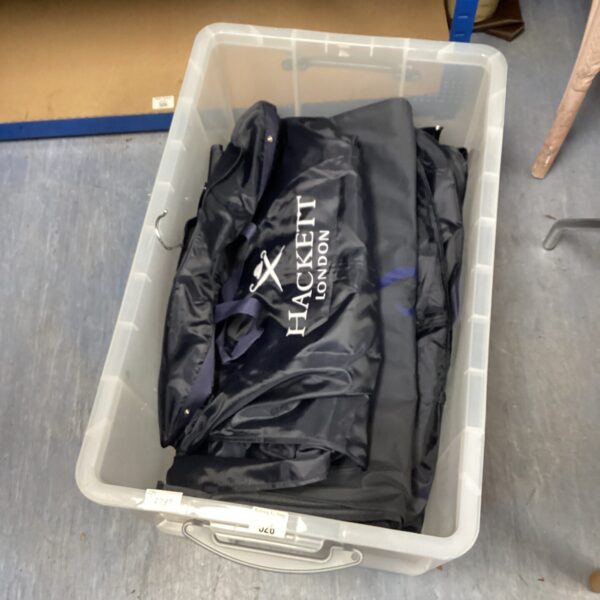A crate of suit covers including Hackett London branded garment bags.
