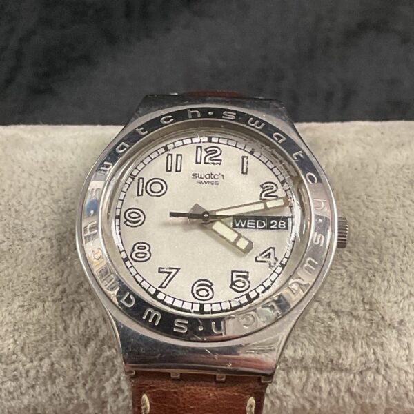 Vintage Swatch watch with two-tone strap and simple dial.