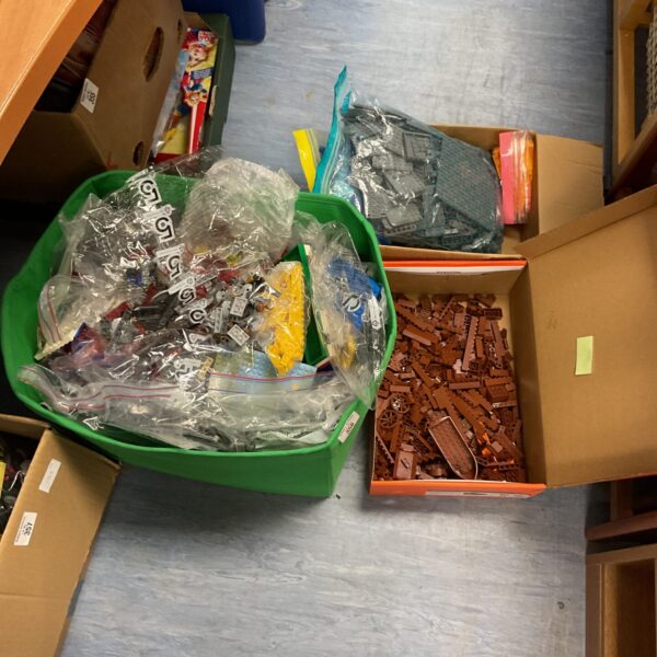 Three boxes filled with a colourful assortment of mixed Lego building blocks.