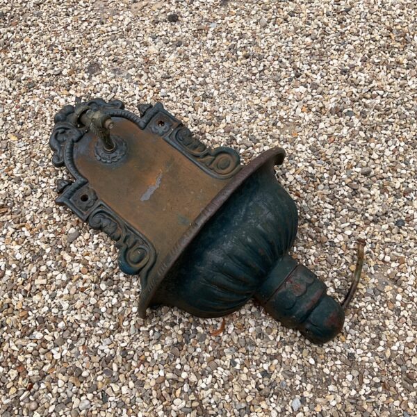 Antique Victorian cast iron fountain with fish tap in garden setting.