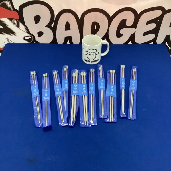 Knitting needles and mug set for crafting projects.