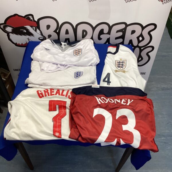 Bundle of vintage England football shirts for collectors and fans.