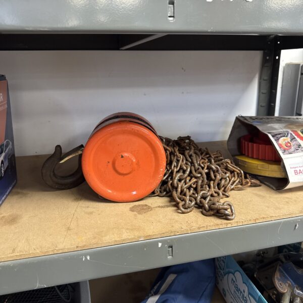 Heavy-duty metal pulley with chain for lifting applications.