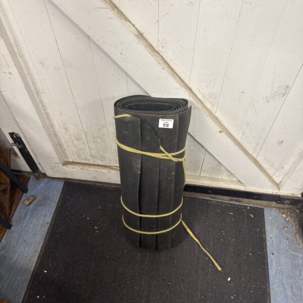 Rolled bundle of heavy-duty rubber floor mats for industrial use.