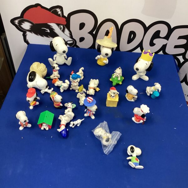 Colorful collection of Snoopy figurines on a blue surface.