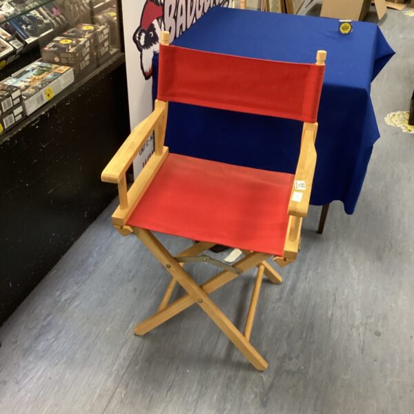 Vintage red folding director's chair with wooden frame.