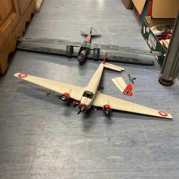 Side view of a vintage model airplane with red markings.