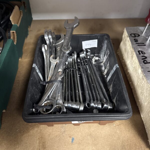Assorted spanners in a tool lot, showing signs of wear.