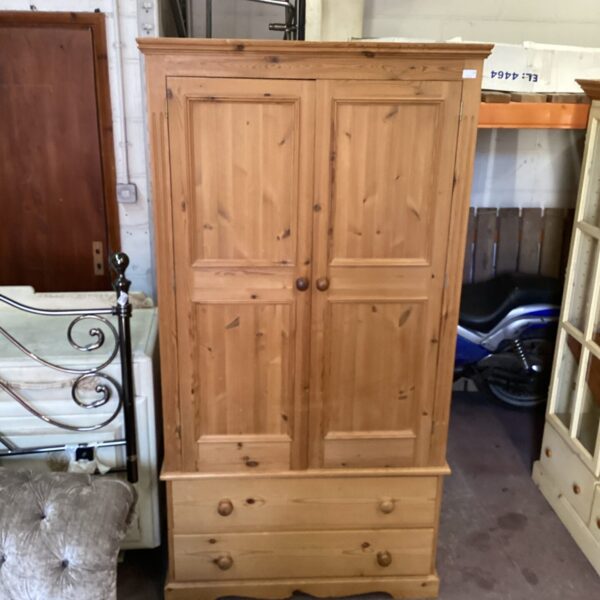 Vintage pine wardrobe with two drawers for bedroom storage.