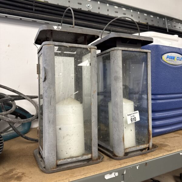 Two vintage candle lanterns with glass panels and metal frames.