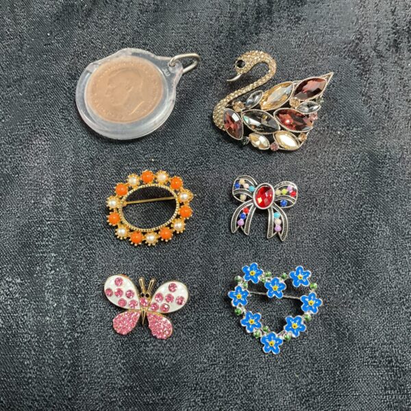 Vintage costume jewellery brooches and penny pendant lot for collectors.