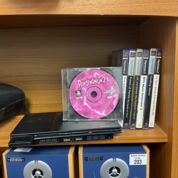 Sony PlayStation 2 slim console with games displayed.