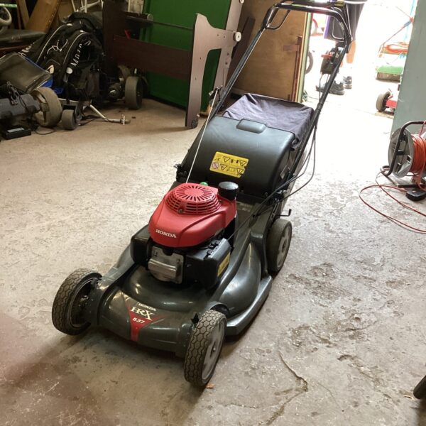 Honda HRX 537 petrol lawnmower in a workshop setting.