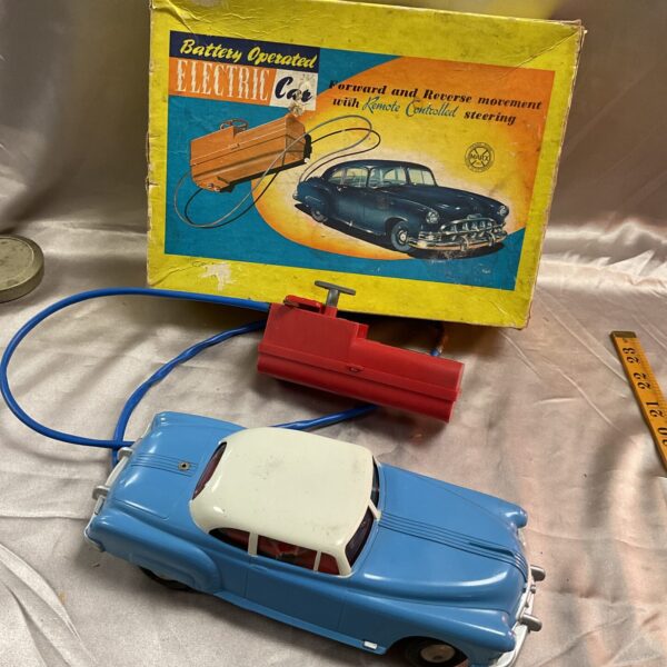 Vintage battery operated tin car in original box, collectible toy.