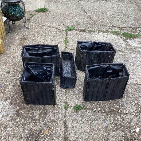 Set of five folding raffia garden planters for outdoor use.