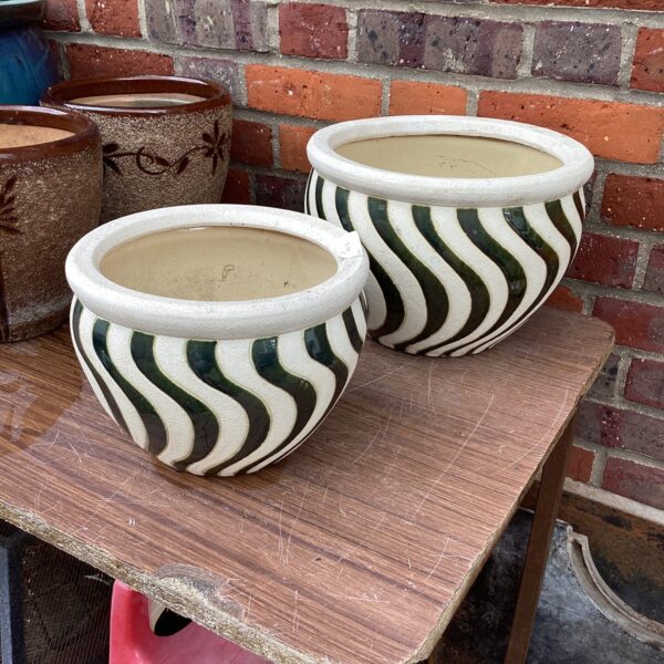 Vintage striped ceramic garden pots for outdoor plants.