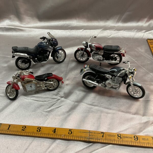 Diecast Triumph motorcycle models and clock collection.