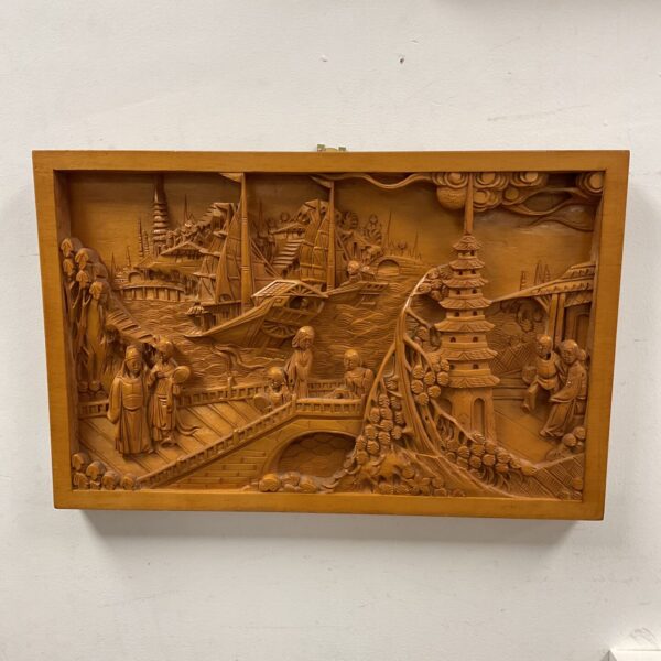 Intricate hand-carved wooden wall panel depicting an oriental landscape.