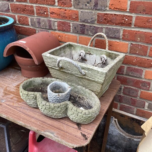 Set of three rustic stone garden planters for outdoor use.