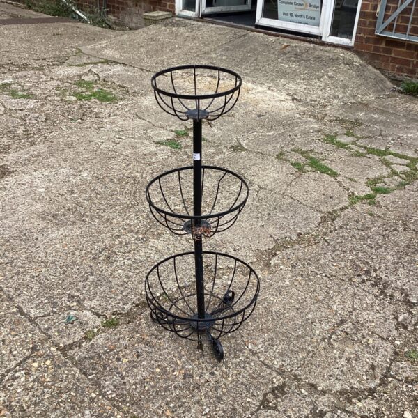 Three-tiered metal garden basket pedestal for outdoor plants.