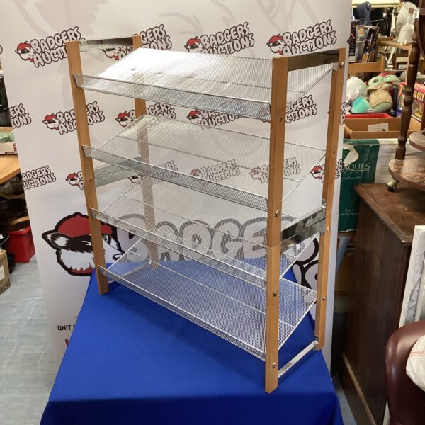 Vintage wooden shoe rack with mesh tiers for storage.