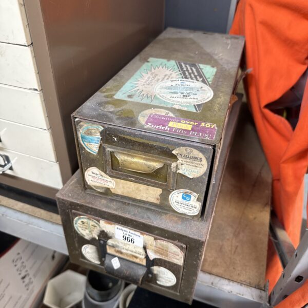 Vintage metal filing drawers with aged patina and labels.