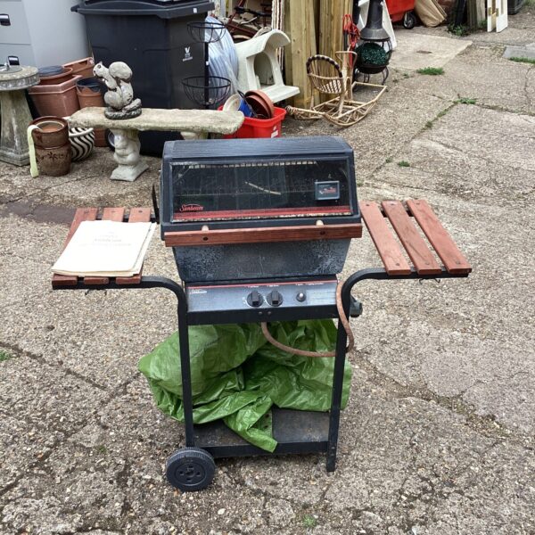 Vintage Sunbeam gas BBQ with cover in a garden setting.