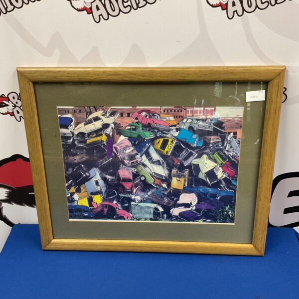 Framed print of a detailed scrap yard with vintage vehicles.
