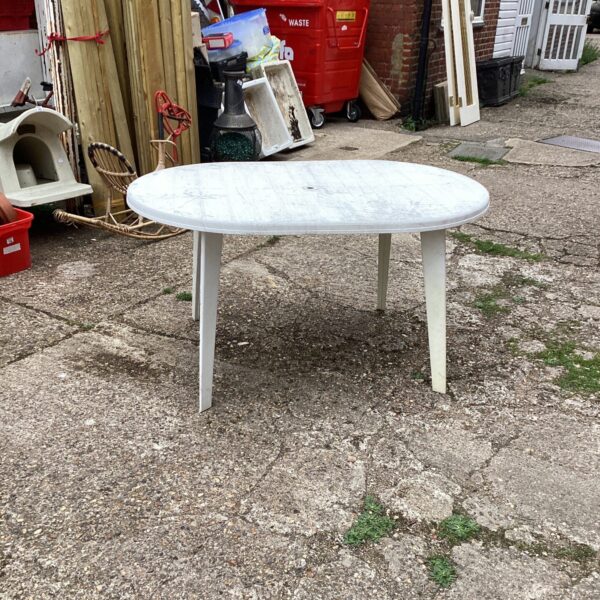 Large white plastic garden table in an outdoor setting.