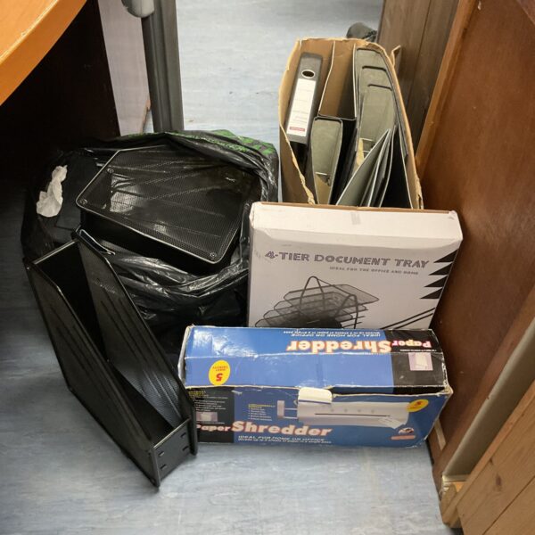 Office storage lot including ring binders and mesh trays.