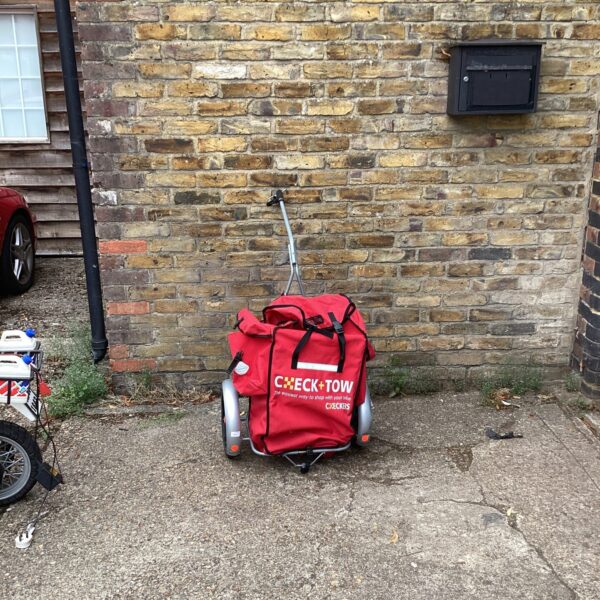 Red vintage Carradice bike cart attached to a bicycle.