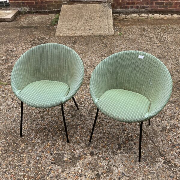 Pair of vintage Lloyd Loom style tub chairs in a garden setting.