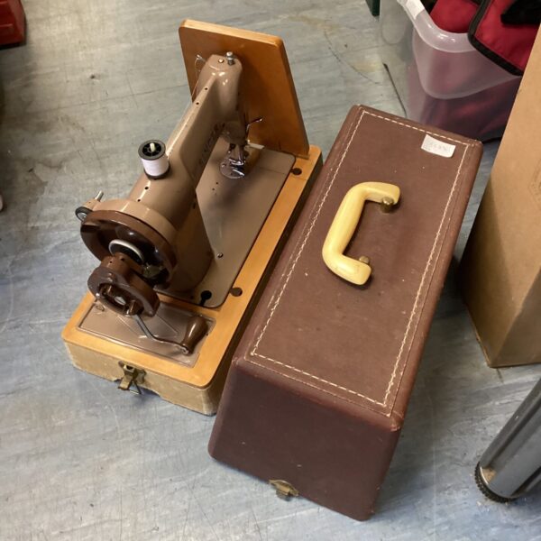 Vintage Singer sewing machine with case, retro collectible.