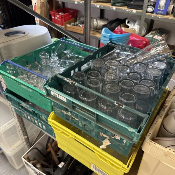 Tray of assorted clear drinking glasses for beverages.