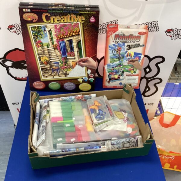 Mixed crafting and drawing supplies in a crate.