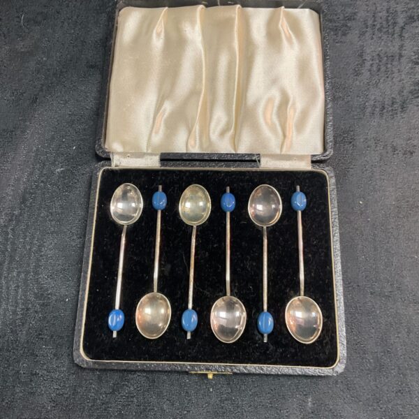 Set of six vintage silverplate coffee bean spoons displayed.