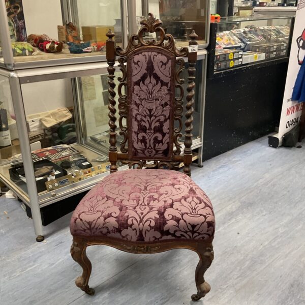 Antique Victorian nursing chair with purple upholstery and carved oak frame.