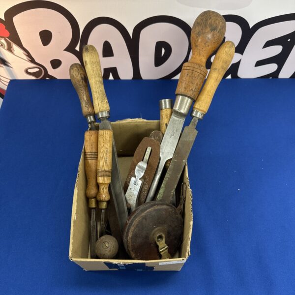 Vintage woodworking tools including hand planes and tape measure.