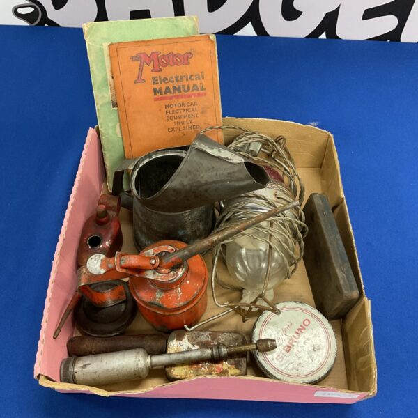 Vintage oil cans, grease gun, and motor car booklets – a collectible automotive lot.