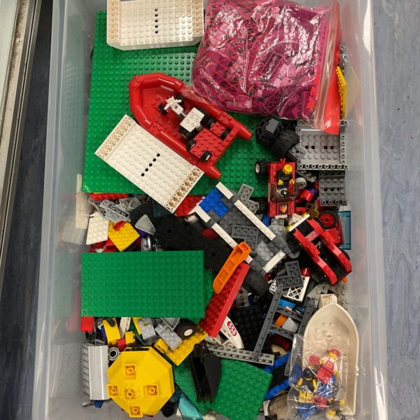 Crate of assorted vintage Lego bricks and minifigures.
