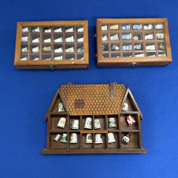 Vintage thimble display cases with thimbles inside.