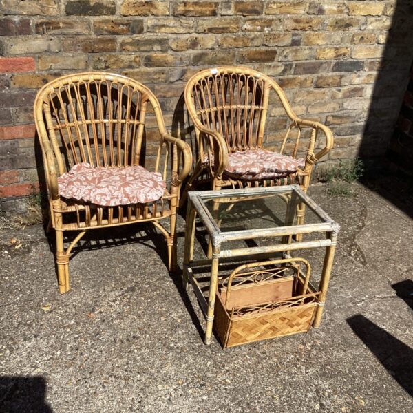 Vintage bamboo patio set with chairs and glass table in garden.
