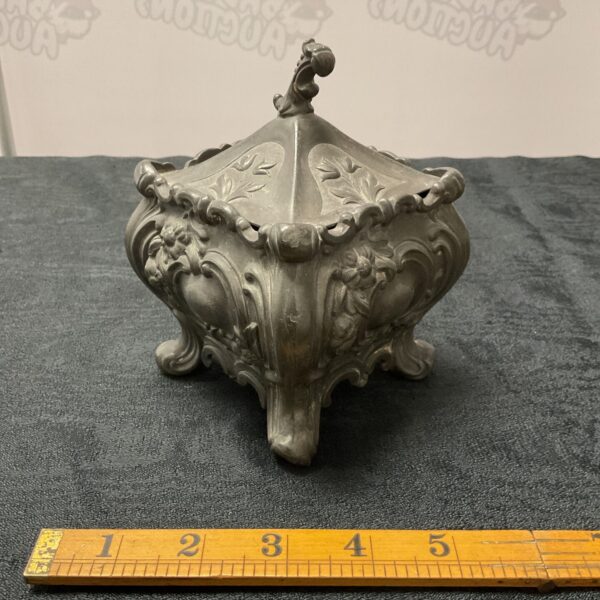 Antique pewter tea caddy with embossed floral design.