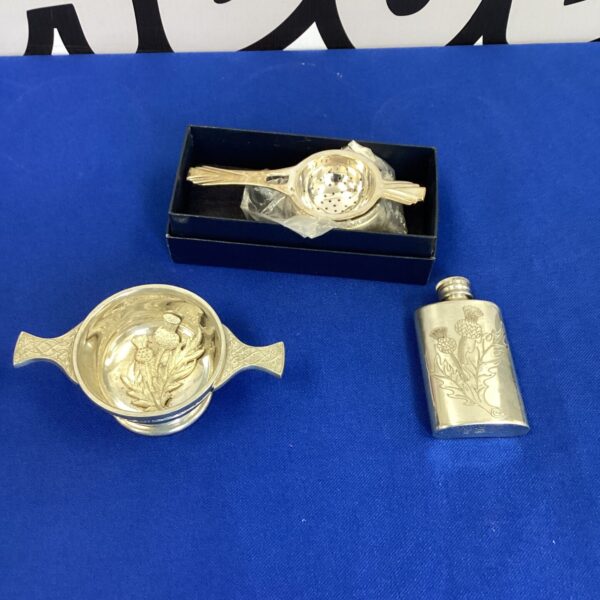 Vintage pewter tea strainer and hip flask set with floral detailing.