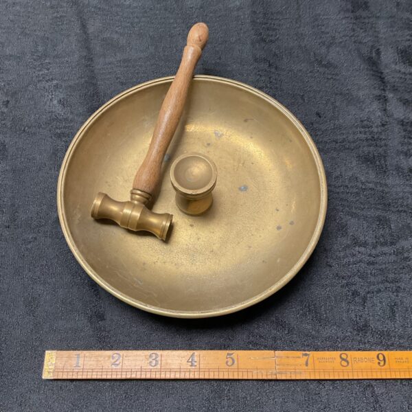Brass Buddhist gong set with wooden hammer for meditation.