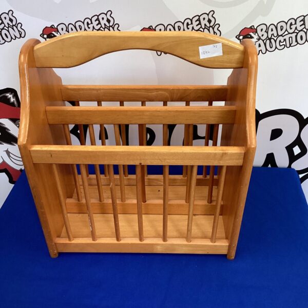 Vintage light oak magazine rack for storing reading materials.